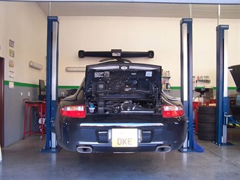 Porsche 911 na zvedáku s otevřeným motorovým prostorem