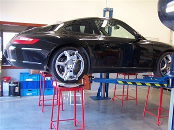 Porsche 911 na zvedáku v dílně autoservisu